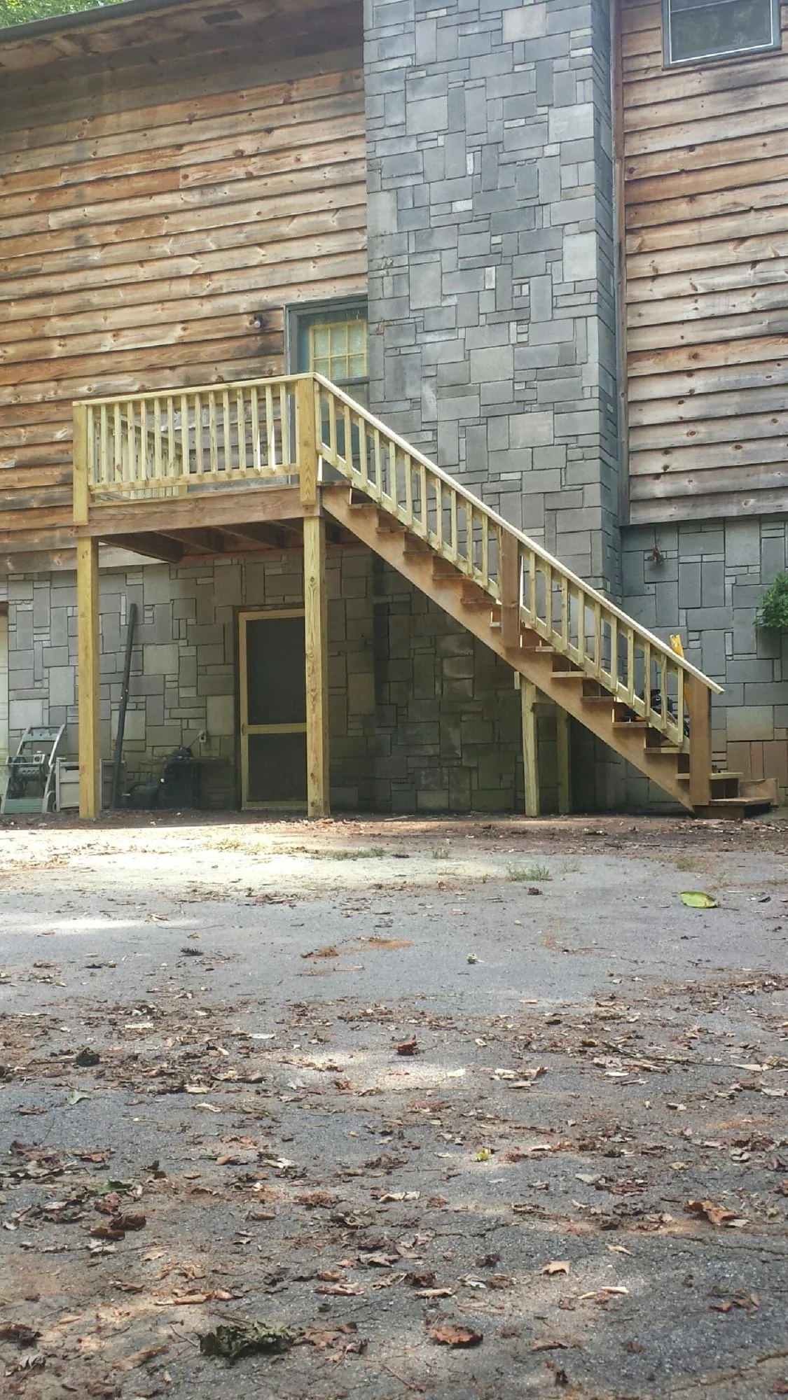 New pressure treated deck and stair landing on a log home in Brownsville
