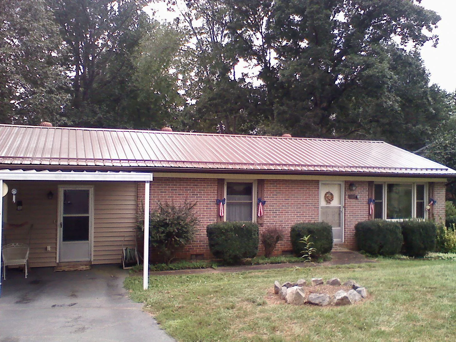 Bronze metal roof and carport on a brick ranch home — Roof Repair work by our crew in Brownsville